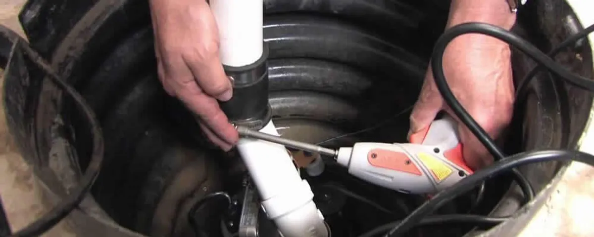 Sump pump installation technician connecting PVC discharge piping in Nashville, TN